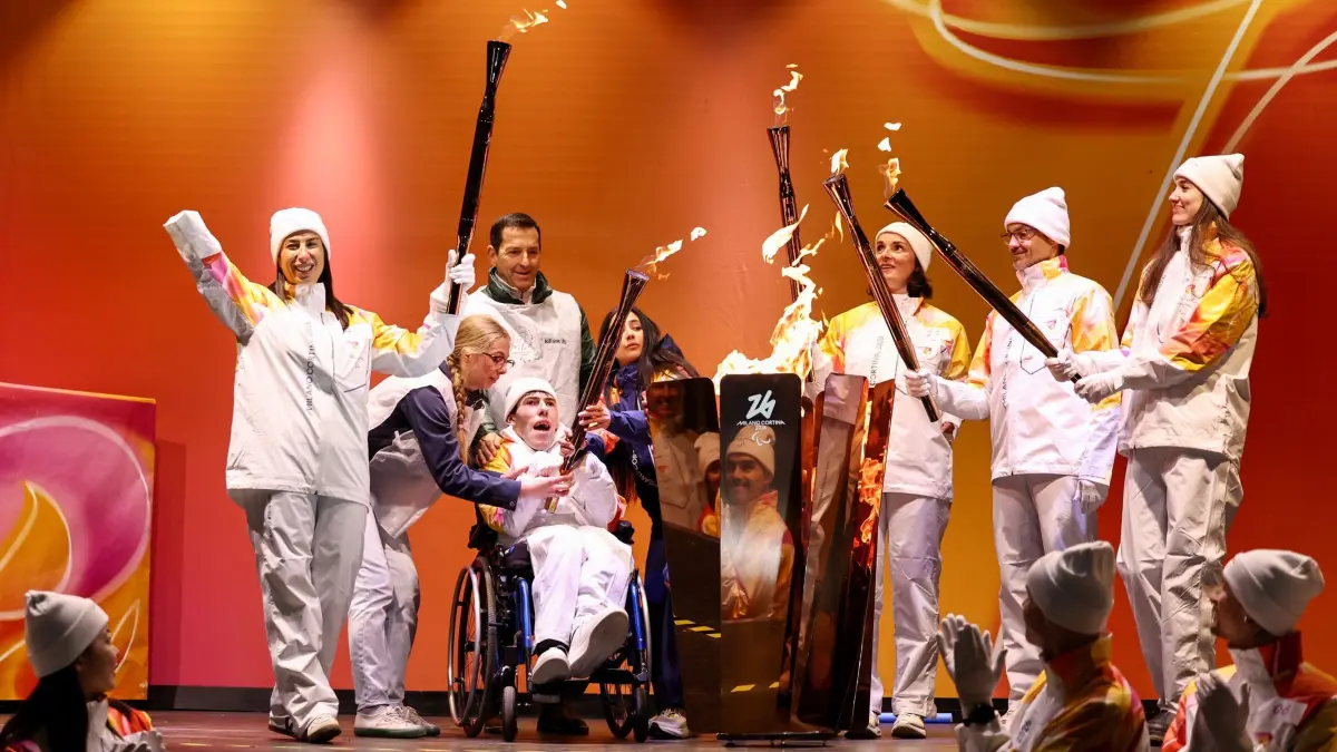 Paralympics in Italien: 03.03.2026, Italien, Cortina D'Ampezz: Fackelträger entzünden den Kessel mit der Flamme der Paralympischen Winterspiele Mailand-Cortina 2026. Foto: Wang Kaiyan/XinHua/dpa +++ dpa-Bildfunk +++