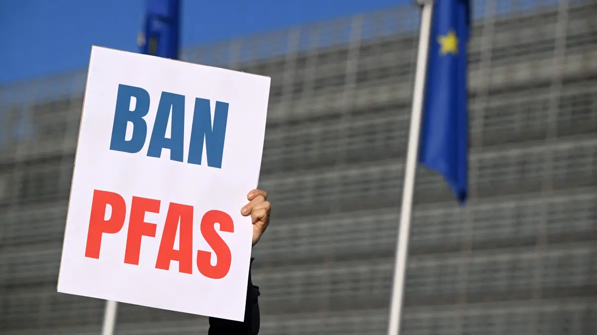 Environmental activists hold placards during a demonstration against PFAS chemicals next to the EU Commission headquarters in Brussels on March 5, 2026. (Photo by Nicolas TUCAT / AFP)