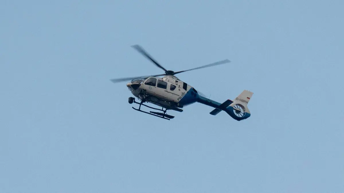 Polizeihubschrauber: ARCHIV - 23.03.2025, Bayern, Parsberg: Ein Polizeihubschrauber fliegt über den Ortsrand. (zu dpa: «Tote Frau aus der Donau geborgen») Foto: Armin Weigel/dpa +++ dpa-Bildfunk +++
