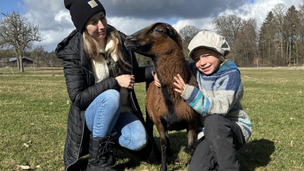 Katharina (6) nimmt Kamerunschaf Laura in den Arm. Die Aue lässt sich das gerne gefallen. Links ist Miriam Speh zu sehen, die das Erlebnisangebot bei Mainhardt anbietet.