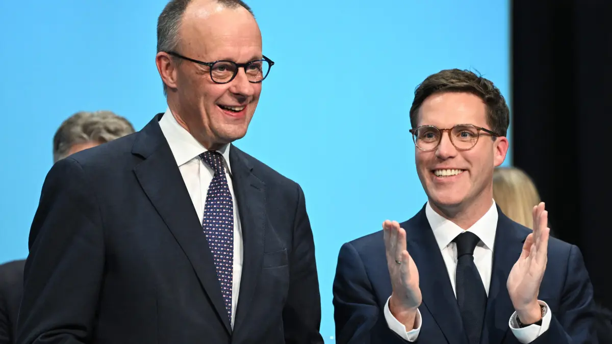 German Chancellor and Chairman of the Christian Democratic Party (CDU) Friedrich Merz (L) and the top candidate of the CDU for the upcoming state elections in the federal state Baden-Wuerttemberg Manuel Hagel acknowledge the audience during an election campaign event in Stockach, southern Germany, on March 6, 2026. Voters will go to the polls in the prosperous southwestern state of Baden-Wuerttemberg on March 8, 2026. (Photo by THOMAS KIENZLE / AFP)