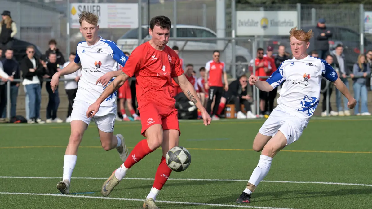Fussball KL A | FC Sonnenbuehl vs. TSV Holzelfingen: Fussball KL A1 | FC Sonnenbuehl (rot) vs. TSV Holzelfingen (weiss) // 2026-03-08 // Foto: Joachim Baur // #6 Volodymyr Naiko (FC Sonnenbuehl) / #8 Fynn Petkovsek (TSV Holzelfingen), re / #27 Felix Taxis (TSV Holzelfingen), li