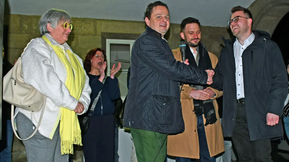 Wahlleiter Philipp Friedlein (Mitte) war der Erste, der Sebastian Mayer (rechts) nach der Bekanntgabe des Wahlergebnisses gratulierte. Direkt neben Mayer: der Zweitplatzierte Pierre Kneifl. Links: die unterlegene Bürgermeisterin Heike Naber.