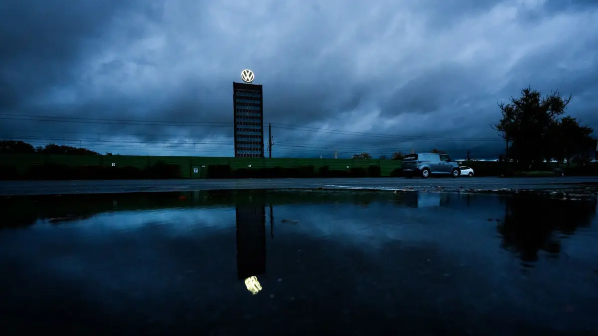 Volkswagen in Wolfsburg: ARCHIV - 30.10.2025, Niedersachsen, Wolfsburg: Dunkle Wolken ziehen über das Markenhochhaus von Volkswagen auf dem Gelände vom VW Stammwerk hinweg. Der VW-Konzern ist im dritten Quartal tief in die roten Zahlen gerutscht und vermeldet in den Monaten Juli bis September ein Verlust von über eine Milliarde Euro. (zu dpa: «Gewinn bei VW 2025 um knapp die Hälfte eingebrochen») Foto: Julian Stratenschulte/dpa +++ dpa-Bildfunk +++