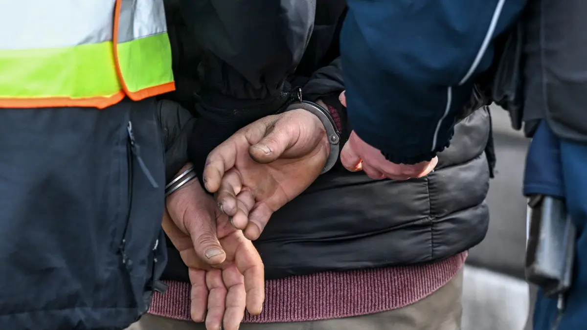 Polizei Berlin: ARCHIV - 23.02.2026, Berlin: Polizisten legen einem Mann Handschellen wegen gefälschter Papiere an. (zu dpa: «Polizei: Weniger Messerangriffe in Berliner Verbotszonen») Foto: Jens Kalaene/dpa +++ dpa-Bildfunk +++