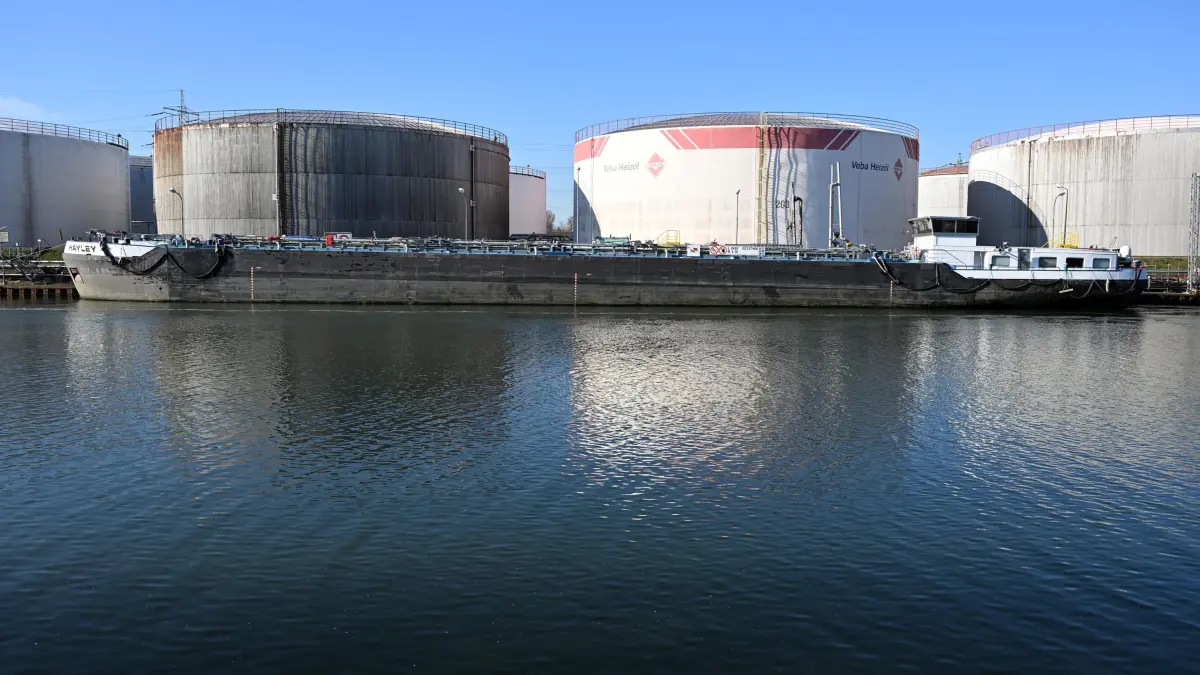 Öltanks am Rhein-Herne-Kanal: ARCHIV - 02.03.2022, Nordrhein-Westfalen, Gelsenkirchen: Ein Tankschiff liegt vor Öltanks am Rhein-Herne-Kanal. (zu dpa: «G7-Energieminister offen für Freigabe von Ölreserven») Foto: Federico Gambarini/dpa +++ dpa-Bildfunk +++