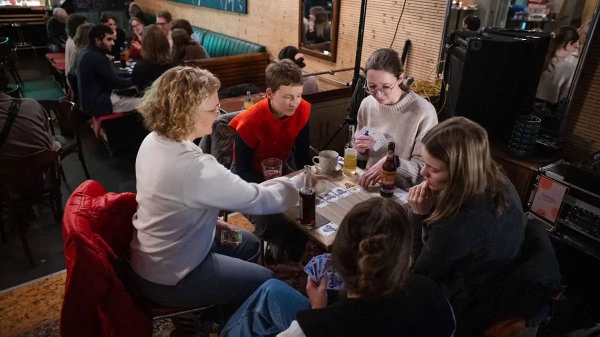 Offline-Café im Café Haag: Die fünf Frauen vorne am Tisch spielen das Kartenspiel "6 nimmt", am Tisch dahinter redet eine Gruppe, die sich vorher ebenfalls nicht kannte.