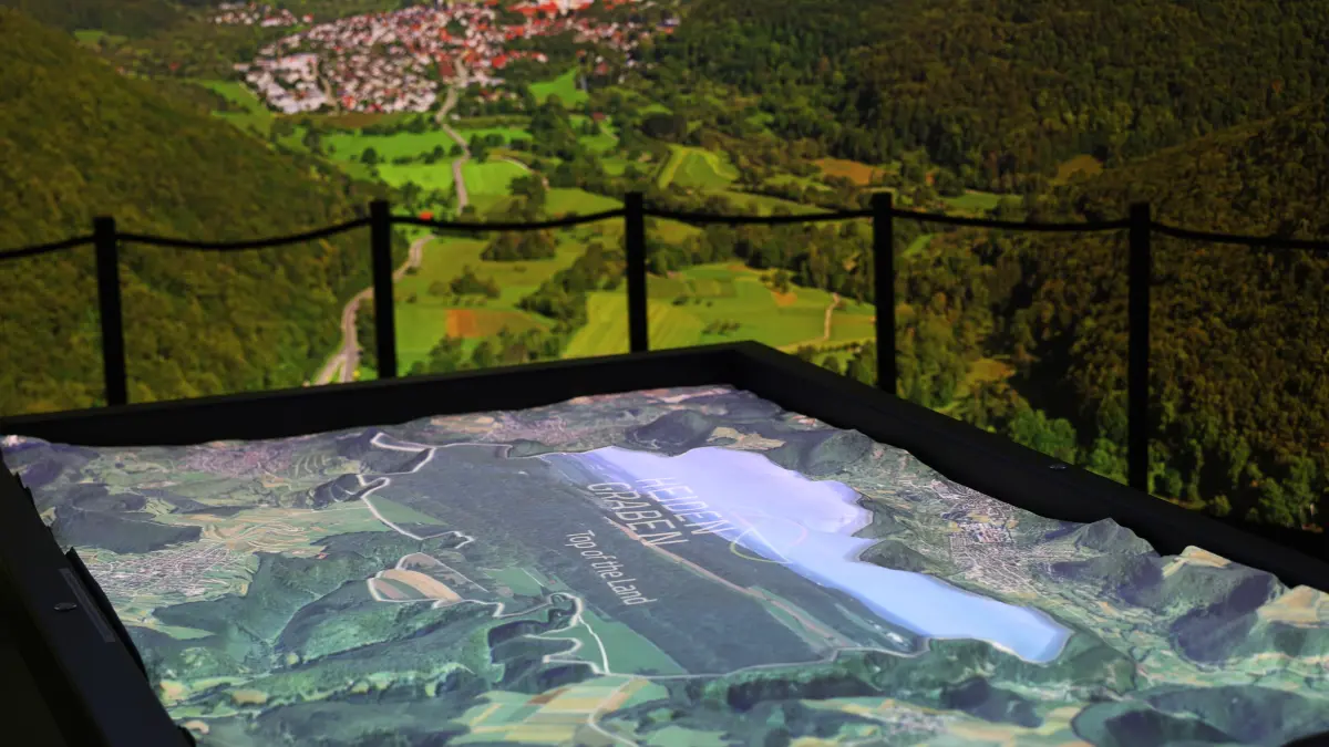 Ein Erklärvideo auf einer Höhenkarte ordnet die Albfläche zwischen Erkenbrechtsweiler, Hülben und Grabenstetten in den damaligen Kontext als Nabel des Handels ein.