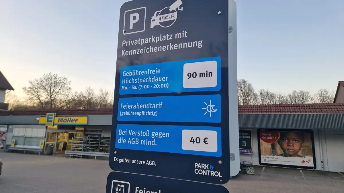 Schilder weisen auf die neue Parkraumüberwachung auf dem Edeka-Parkplatz in der Gaildorfer Bahnhofstraße hin.