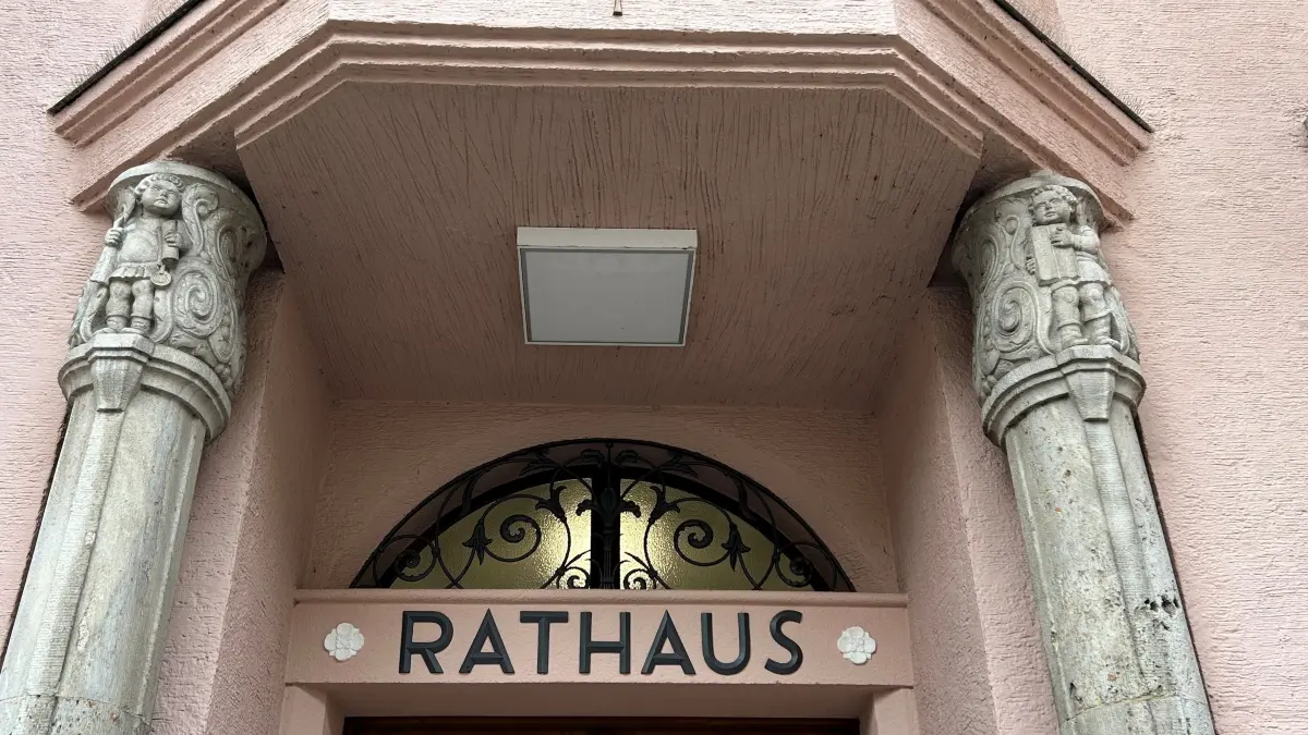 Altstadt-Serie, Altstadtserie, Altstadt im Blickpunkt - Folge 27 - Neues Rathaus Geislingen - Vielgestaltiger Haupteingang. Der Ausschnitt zeigt Steinfiguren an den Säulen, links eine Person mit Urkundenrolle und Siegel, rechts eventuell mit einem Gesetzbuch.