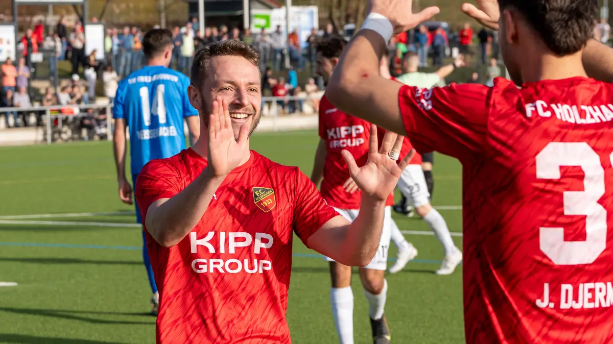 Henry Seeger (links, FC Holzhausen) feiert mit Jovan Djermanovic.