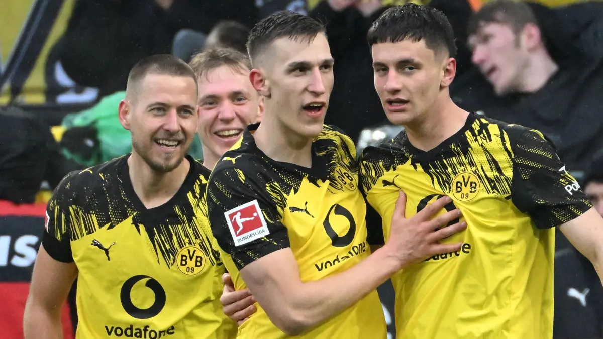 Dortmund's Italian defender #49 Luca Reggiani (R) celebrates scoring his team's second goal with Dortmund's German defender #04 Nico Schlotterbeck and team mates during the German first division Bundesliga football match between BVB Borussia Dortmund and FC Augsburg in Dortmund, western Germany on March 14, 2026. (Photo by UWE KRAFT / AFP) / DFL REGULATIONS PROHIBIT ANY USE OF PHOTOGRAPHS AS IMAGE SEQUENCES AND/OR QUASI-VIDEO
