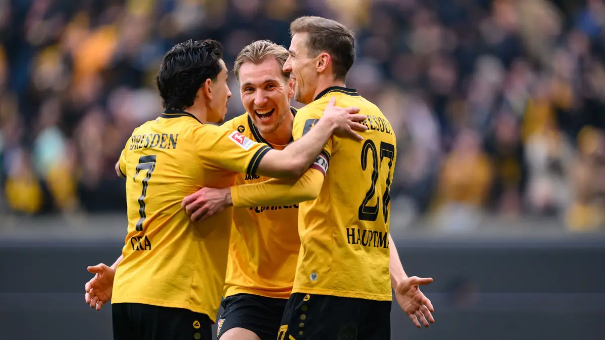 SG Dynamo Dresden - Preußen Münster: 15.03.2026, Sachsen, Dresden: Fußball, Männer: 2. Bundesliga, SG Dynamo Dresden - Preußen Münster, 26. Spieltag, Rudolf-Harbig-Stadion, Niklas Hauptmann (Dynamo Dresden, r) jubelt nach seinem Tor zum 3:0 mit Jason Ceka (Dynamo Dresden, l) und Vincent Vermeij (Dynamo Dresden). Foto: Robert Michael/dpa - WICHTIGER HINWEIS: Gemäß den Vorgaben der DFL Deutsche Fußball Liga bzw. des DFB Deutscher Fußball-Bund ist es untersagt, in dem Stadion und/oder vom Spiel angefertigte Fotoaufnahmen in Form von Sequenzbildern und/oder videoähnlichen Fotostrecken zu verwerten bzw. verwerten zu lassen. +++ dpa-Bildfunk +++