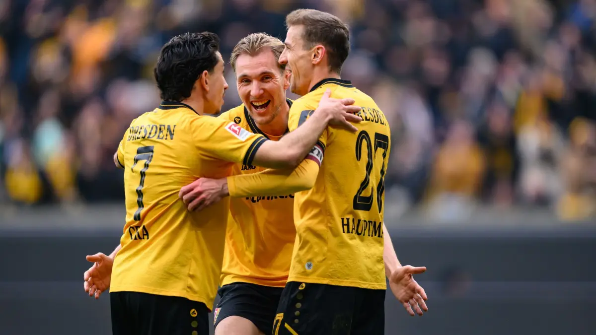 SG Dynamo Dresden - Preußen Münster: 15.03.2026, Sachsen, Dresden: Fußball, Männer: 2. Bundesliga, SG Dynamo Dresden - Preußen Münster, 26. Spieltag, Rudolf-Harbig-Stadion, Niklas Hauptmann (Dynamo Dresden, r) jubelt nach seinem Tor zum 3:0 mit Jason Ceka (Dynamo Dresden, l) und Vincent Vermeij (Dynamo Dresden). Foto: Robert Michael/dpa - WICHTIGER HINWEIS: Gemäß den Vorgaben der DFL Deutsche Fußball Liga bzw. des DFB Deutscher Fußball-Bund ist es untersagt, in dem Stadion und/oder vom Spiel angefertigte Fotoaufnahmen in Form von Sequenzbildern und/oder videoähnlichen Fotostrecken zu verwerten bzw. verwerten zu lassen. +++ dpa-Bildfunk +++