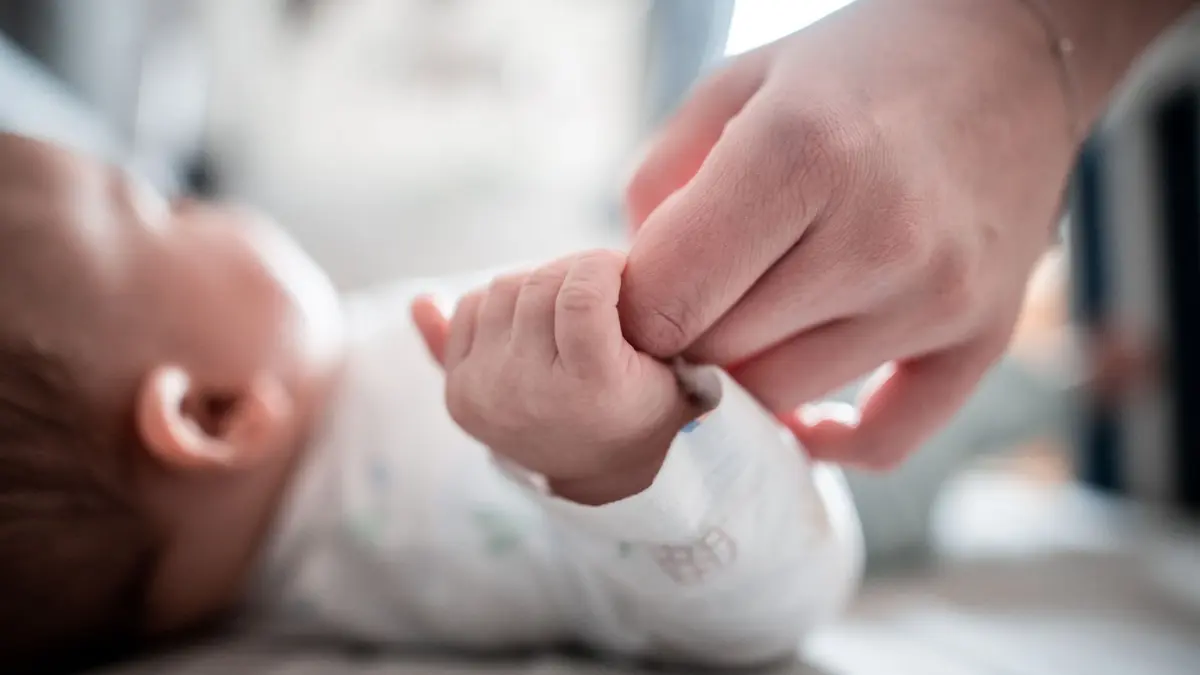 ARCHIV - 30.12.2019, Nordrhein-Westfalen, Oberhausen: Ein Baby klammert sich an den Finger seiner Mutter.
Der Laut «m» ist für Babys leicht zu bilden und kommt in den meisten Sprachen vor. (zu dpa: «Schlaf oder stirb: Wiegenlieder haben mitunter rabiate Texte») Foto: Fabian Strauch/dpa +++ dpa-Bildfunk +++