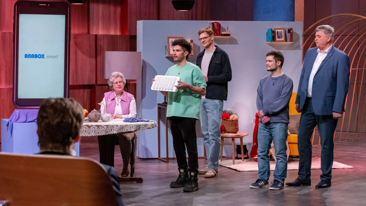 Robert Gühne, Chris Walter, Daniel Böber und Jürgen Burkert (v.l.n.r.) präsentieren den digitalen Medikamentenspender Anabox smart. Seniorin Jutta unterstützt sie bei dem Pitch und repräsentiert die Zielgruppe.