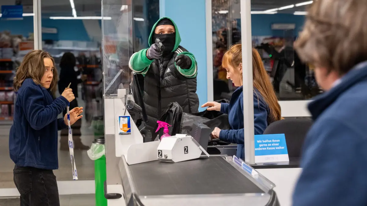 Überfall auf einen Discounter. Der Täter im grünen Jogginganzug bedroht die Angestellten. Doch dann stören Zeugen die Tat.