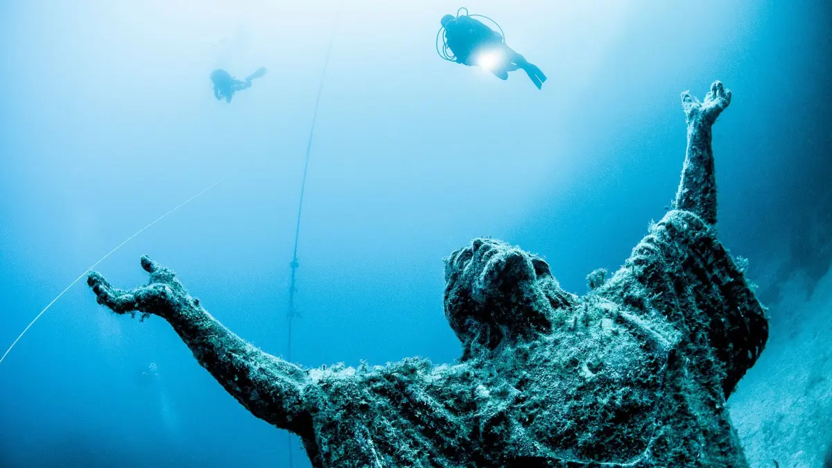 Taucher bei der Statue „Kristu tal-Baħħara“ vor der Küste Maltas: HANDOUT - Ein beliebtes Ziel für Taucher: die Statue «Kristu tal-Baħħara» (Christus der Seefahrer) vor der Küste Maltas, die 1990 zu Ehren des Besuchs von Papst Johannes Paul II. auf dem Meeresgrund aufgestellt wurde. (zu dpa: «Outdoor-Tipps: Malta auf die abenteuerliche Tour») Foto: Matthew Farrugia/VisitMalta/dpa-tmn - ACHTUNG: Nur zur redaktionellen Verwendung im Zusammenhang mit dem genannten Text und nur bei vollständiger Nennung des vorstehenden Credits - Honorarfrei nur für Bezieher des dpa-Themendienstes +++ dpa-Themendienst +++