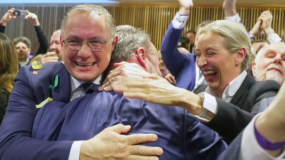Landtagswahl in Rheinland-Pfalz: 22.03.2026, Rheinland-Pfalz, Mainz: Jan Bollinger (M, AfD), Spitzenkandidat seiner Partei, umarmt Tino Chrupalla (AfD), Vorsitzender der AfD-Bundestagsfraktion, bei der Wahlparty der AfD im Abgeordnetenhaus. Rechts steht Alice Weidel (AfD), Vorsitzende der AfD-Bundestagsfraktion. Am Sonntag hat in Rheinland-Pfalz die Landtagswahl stattgefunden. Foto: Andreas Arnold/dpa +++ dpa-Bildfunk +++