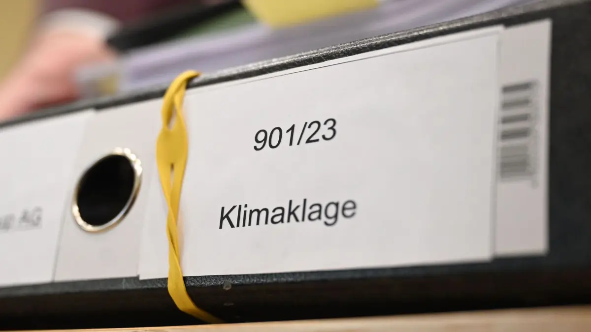 BGH verhandelt über Klimaklagen zu Verbrenner-Aus: ARCHIV - 02.03.2026, Baden-Württemberg, Karlsruhe: Ein Aktenordner mit der Aufschrift «Klimaklage» liegt in einem Sitzungssaal des Bundesgerichtshofs (BGH) auf einem Tisch. Die Deutsche Umwelthilfe klagt vor dem BGH gegen BMW und Mercedes-Benz. Sie fordert unter anderem, dass die Dax-Konzerne ab November 2030 keine herkömmlichen Verbrenner mehr verkaufen dürfen, die Treibhausgase ausstoßen. (zu dpa: «Verbrenner-Aus 2030? BGH urteilt zu Klagen gegen Autobauer») Foto: Uli Deck/dpa +++ dpa-Bildfunk +++