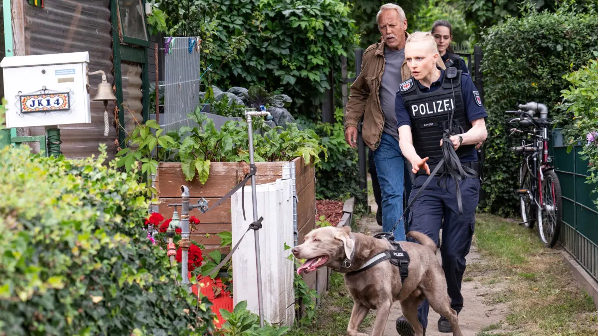 Kommissar Karl Rogov (Frank Leo Schröder, l.) und seine Kollegin Grit Klemke (Anne Müller, r.) verfolgen die Spur eines flüchtigen Täters zu einer Gartenlaube.
