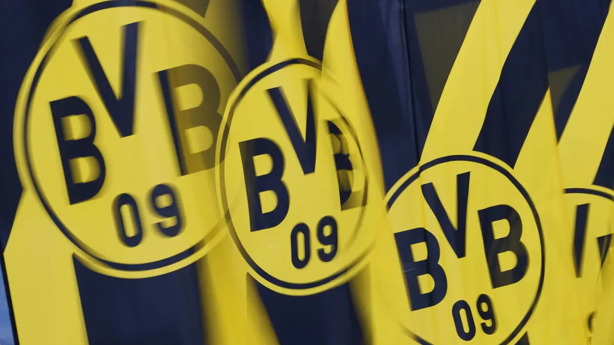 Borussia Dortmund: ARCHIV - 25.11.2024, Nordrhein-Westfalen, Dortmund: Borussia Dortmund GmbH & Co. KGaA - Hauptversammlung, Kongresszentrum Westfalenhallen. Fahnen mit dem BVB-Logo flattern vor der Veranstaltungshalle im Wind. Die Missbrauchsvorwürfe bei Borussia Dortmund weiten sich aus. (zu dpa: «17 Fälle bis 2017: BVB-Missbrauchsvorwürfe weiten sich aus») Foto: Bernd Thissen/dpa +++ dpa-Bildfunk +++