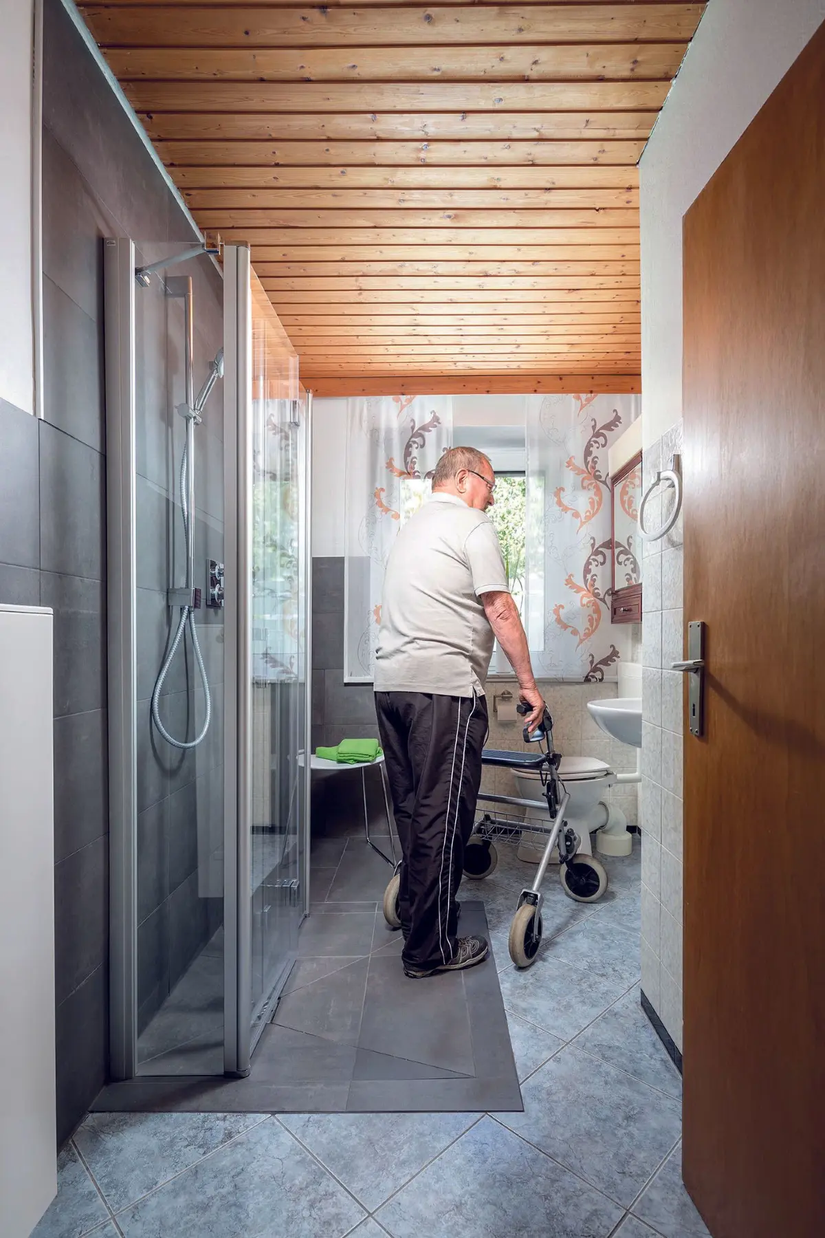 Nach dem Umbau: ein Bad für alle Lebenslagen. Die wegfaltbare Liga Duschkabine in Pendel-Falt-U-Form ermöglicht barrierefreies, flexibles Duschen – ob mit Gehhilfe oder Duschstuhl. Bei Nichtgebrauch lassen sich die Türen auf weniger als 40 cm platzsparend an die Wand klappen. Foto: Kermi Duschdesign GmbH/akz-o