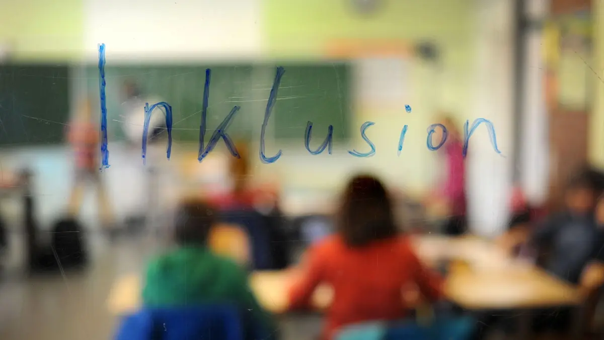 ILLUSTRATION - Schüler sitzen am 24.02.2014 in der Inklusions-Klasse 5a des König-Wilhelm-Gymnasiums in Höxter (Nordrhein-Westfalen) unter dem Schriftzug "Inklusion" (Aufnahme durch eine beschriebene Glasscheibe hindurch). Am 25.03.2014 tagt die Präsidiumssitzung des Städte- und Gemeindebunds NRW u.a. mit Beratungen über die Kosten der Inklusion und den Landesentwicklungsplan. Das Gremium will beschlieÃen, ob es das Finanzierungsangebot des Landes für den gemeinsamen Unterricht von Kindern mit und ohne Behinderung annimmt. Der Städtetag ist bereits dafür, der Landkreistag entscheidet erst am 8. April. Foto: Jonas Güttler/dpa ++ +++ dpa-Bildfunk +++