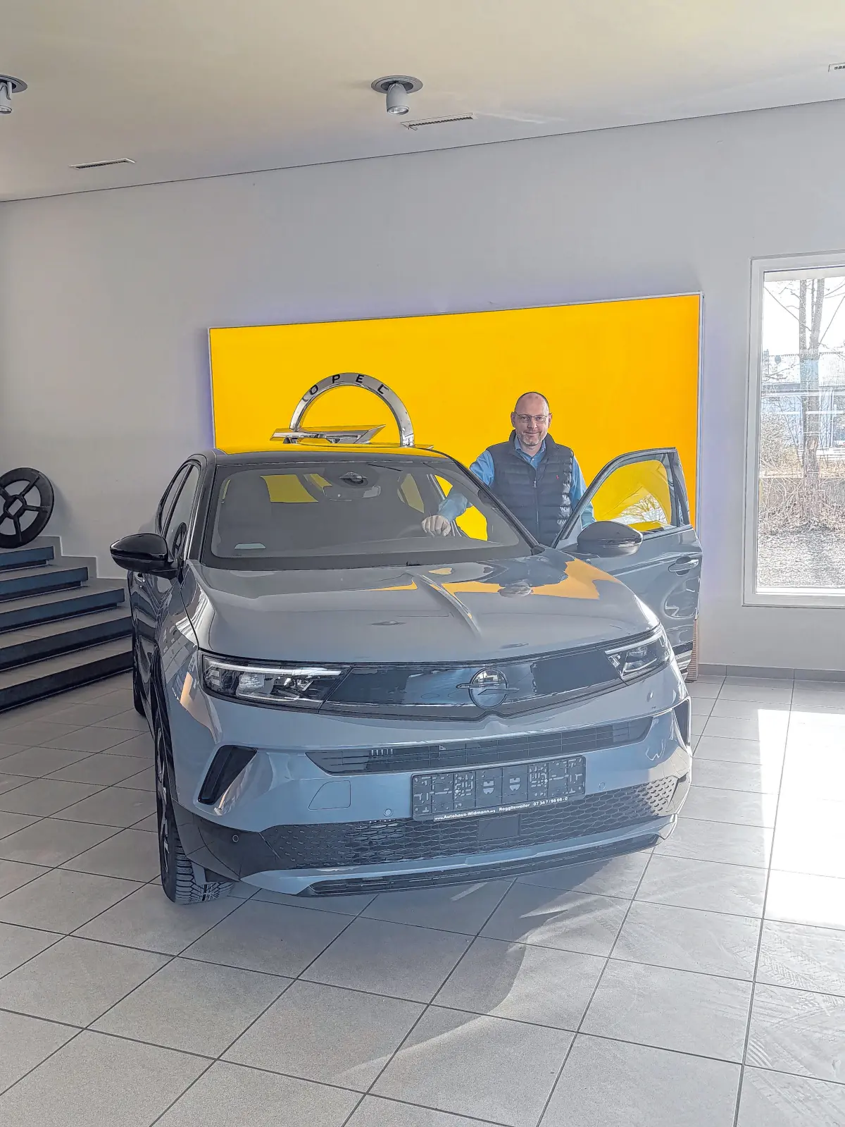 In seinem Showroom präsentiert Jochen Widmann die neuesten Opel-Modelle (linkes Bild). Und Jannik Widmann hält sichtlich stolz seinen Meisterbrief in Händen. ⇥Fotos: Ulla Widmann; Sabrina Hartmann