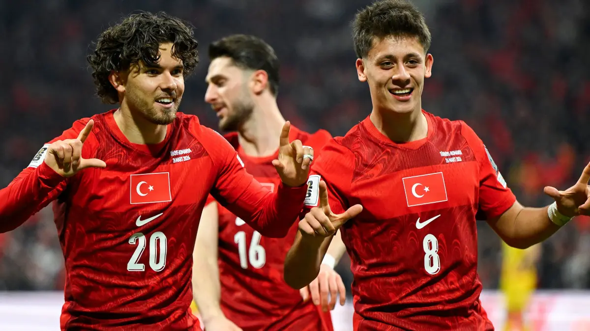 Turkey's defender #20 Ferdi Kadioglu (L) celebrates with Turkey's midfielder #16 Ismail Yuksek (C) and Turkey's midfielder #08 Arda Guler (R) after scoring his team first goal during the play-off FIFA World Cup 2026 European qualification knockout semi-final football match between Turkey and Romania at Besiktas Park stadium, in Istanbul on March 26, 2026. (Photo by YASIN AKGUL / AFP)