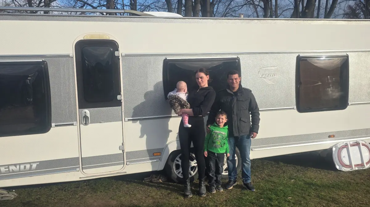 Stolz präsentiert die Zirkusfamilie den gebrauchten Wohnwagen, der von den Spendengeldern gekauft werden konnte.