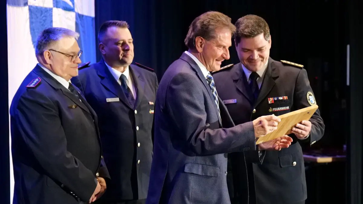 Zum Abschied überreicht der Eislinger Feuerwehrkommandant Mario Feller (rechts) Oberbürgermeister Klaus Heininger ein persönliches Präsent.