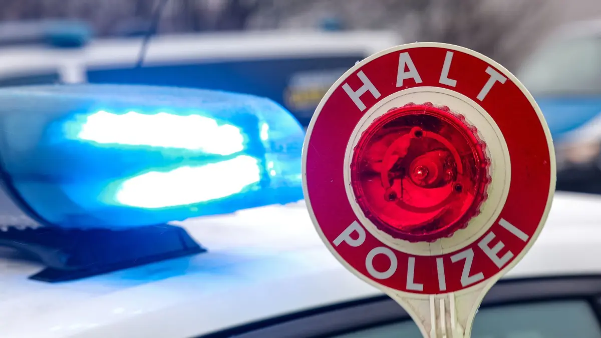 Ein Polizist hält eine Polizeikelle für eine Kontrolle auf einem Parkplatz an der Autobahn 72. (zu dpa: «Flucht mit geklautem Bus: Polizei vermutet zweiten Diebstahl») +++ dpa-Bildfunk +++
