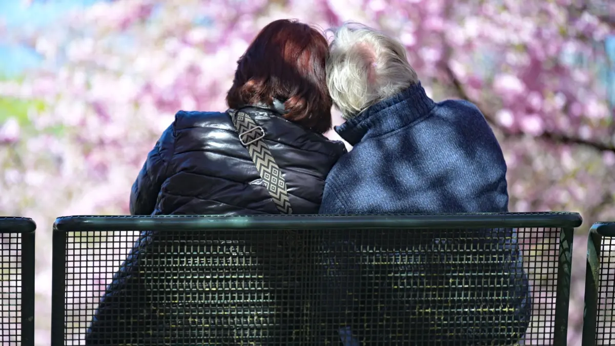 Wetter in Bayern: 07.04.2026, Bayern, München: Ein älteres Paar sitzt auf einer Bank im Olympiapark. Nach einer kühlen Phase bringt der Frühling milde Temperaturen und viel Sonne nach Bayern. Nur an einzelnen Orten kann es noch etwas länger dauern. Foto: Malin Wunderlich/dpa +++ dpa-Bildfunk +++