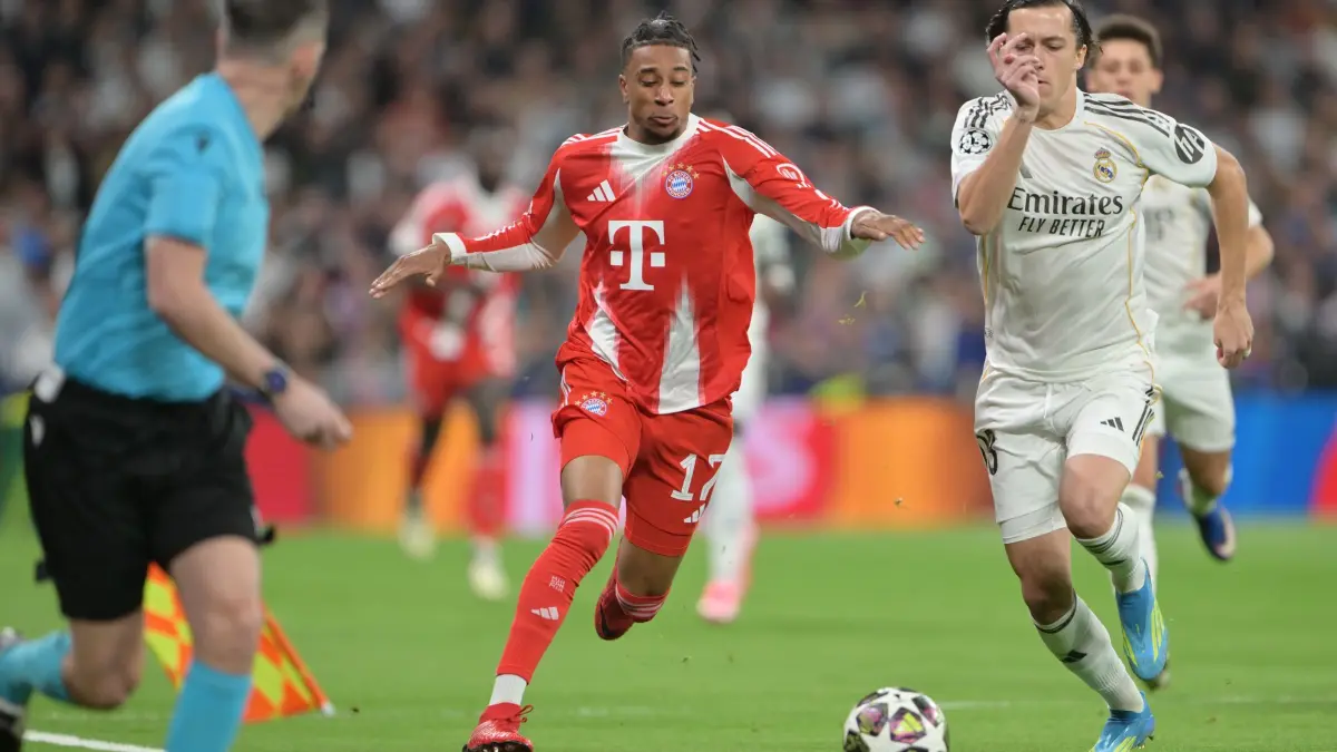 Real Madrid - FC Bayern München: 07.04.2026, Spanien, Madrid: Fußball, Männer: Champions League, Real Madrid - Bayern München, K.o.-Runde, Viertelfinale, Hinspiele, Santiago Bernabeu, Michael Olise (Bayern München) und Alvaro Carreras (r, Real Madrid) kämpfen um den Ball. Foto: Peter Kneffel/dpa +++ dpa-Bildfunk +++