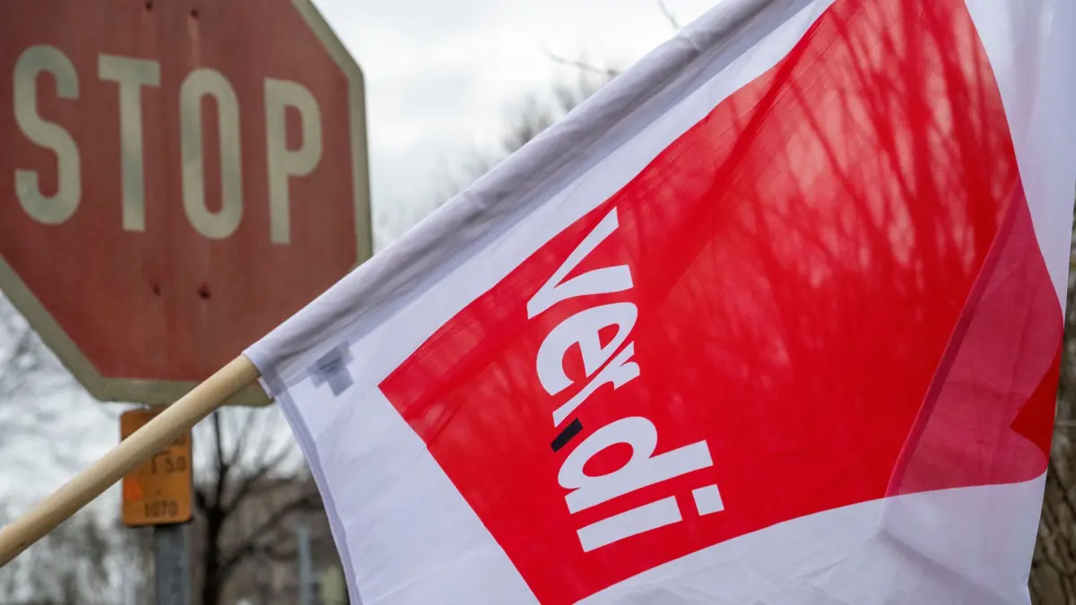 ARCHIV - 19.02.2026, Bayern, Augsburg: Eine Flagge der Gewerkschaft Verdi weht vor einem Stoppschild. (zu dpa: «Verdi ruft zu zweitägigem Warnstreik im Ulmer Nahverkehr auf») Foto: Stefan Puchner/dpa +++ dpa-Bildfunk +++