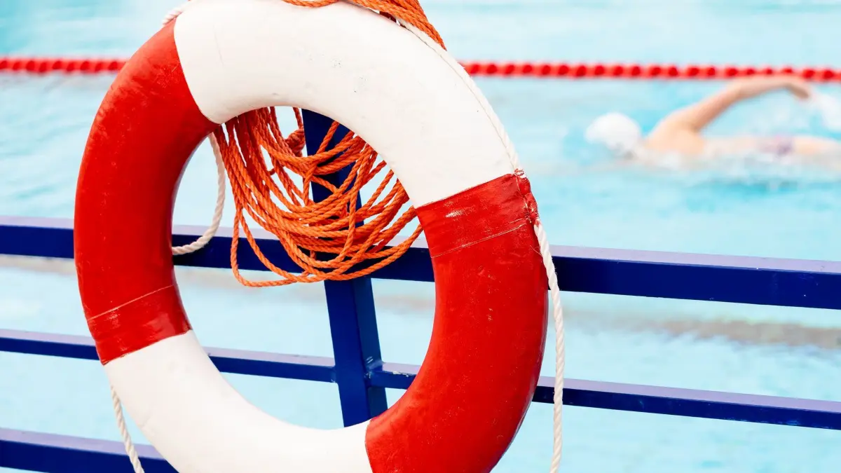 In Sachsen-Anhalt fehlen Rettungsschwimmer: ARCHIV - 13.05.2021, Niedersachsen, Hannover: Ein Rettungsring hängt an einem Geländer am Becken eines Freibads. In Sachsen-Anhalt fehlen laut der DLRG vielerorts Rettungsschwimmer für die anstehende Freibadsaison, vor allem ausgebildete hauptberufliche Bademeister werden gesucht. (zu dpa: «Zu Freibadsaison: Sachsen-Anhalt fehlen Rettungsschwimmer») Foto: Moritz Frankenberg/dpa +++ dpa-Bildfunk +++