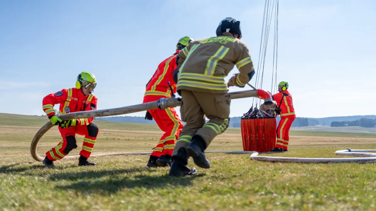Feuerwehrleute befüllen ein Bambi Bucket.