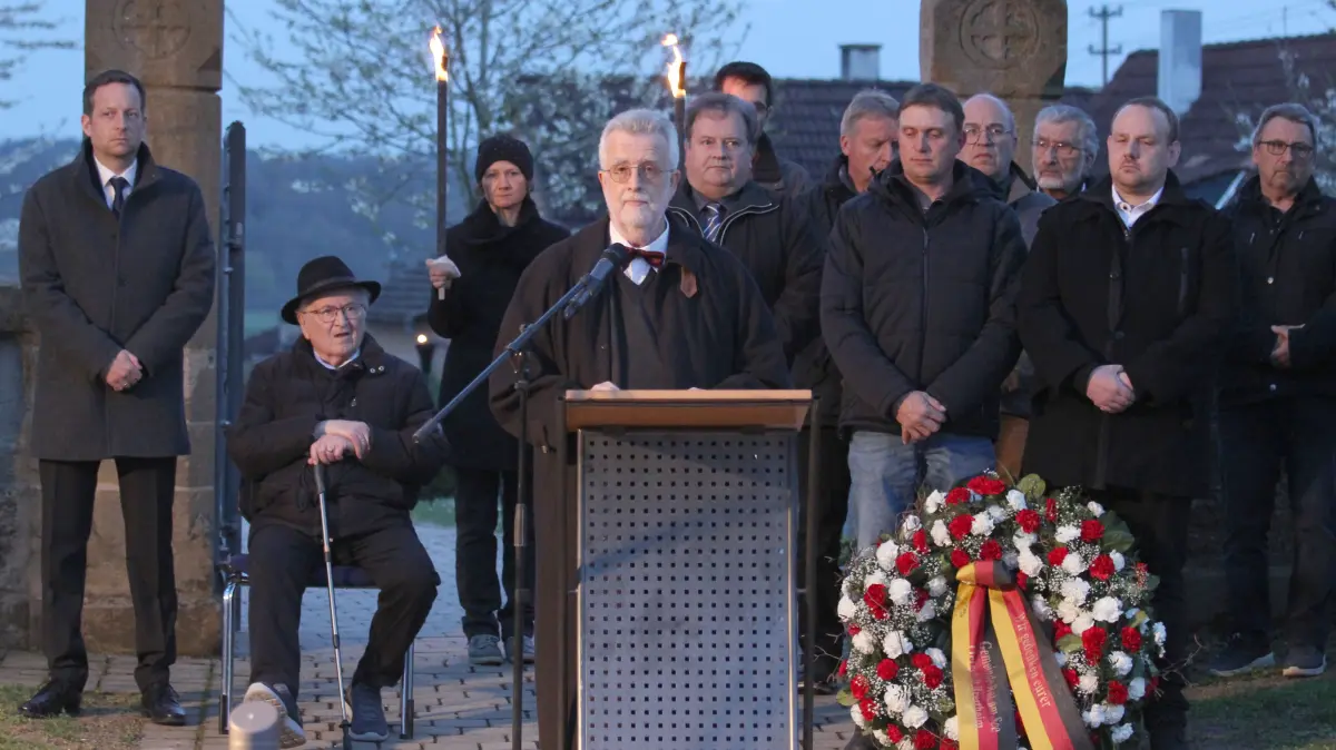 Gedenken an die "Männer von Brettheim", 10. April 2026. Prof. Dr. Thomas Schnabel bei seiner Gedenkrede. Links hinten: Bürgermeister Dr. Sebastian Kampe und Gedenkstätten-Initiator Fritz Braun. Rechts hinter Schnabel: Ortsvorsteher Reiner Groß
