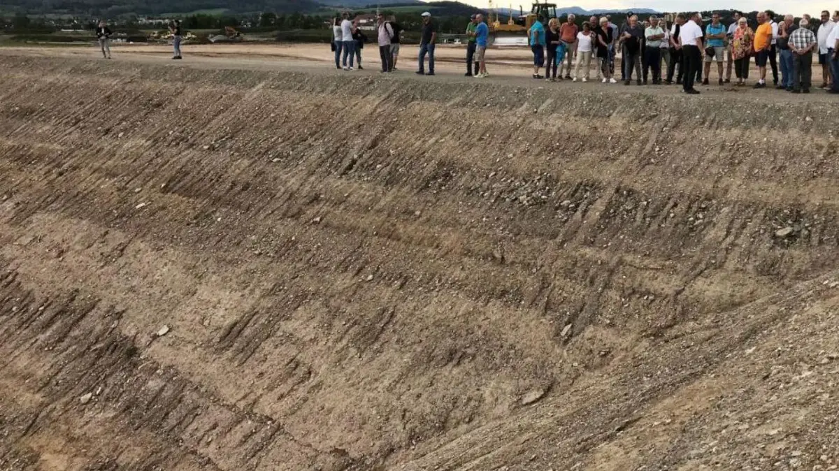 Das riesige Speicherbecken auf dem Hechinger Killberg ist weiterhin im Befüllungsstadium. Bei der Besichtigung des Bauwerks wurden die Dimensionen erstmals richtig deutlich: Die kleinen Menschen sind Mitglieder der Stadtverwaltung und des Gemeinderates sowie ein kleiner Teil der interessierten Einwohnerschaft. Das Becken ist wichtiger Bestandteil des klimaneutralen Fernwärmenetzes im bundesweit beachteten Hechinger Neubaugebiet.