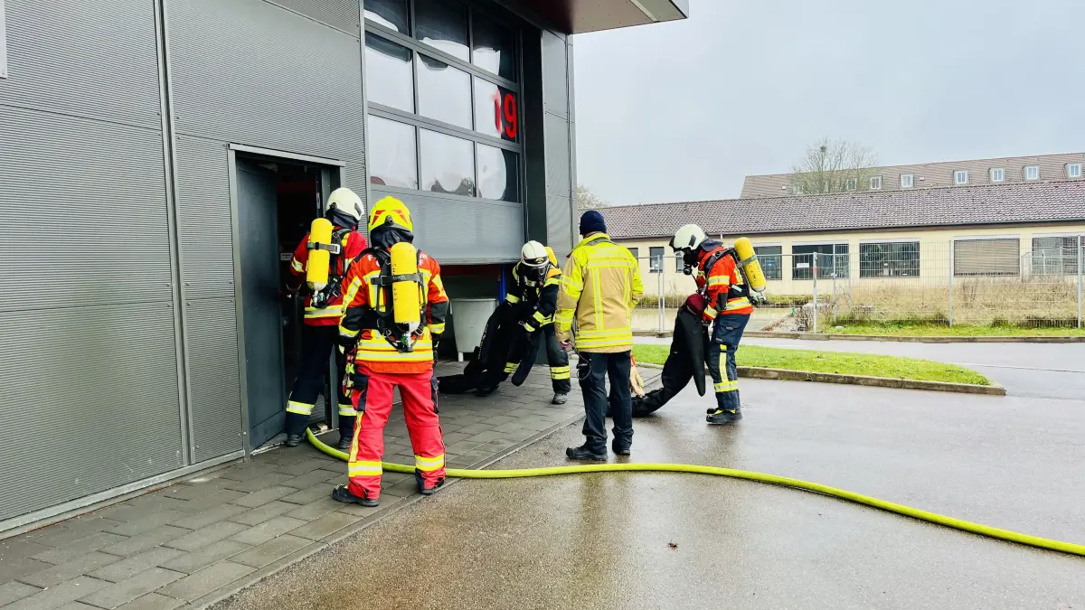 Die 75 Kilogramm schwere Übungspuppe, die die Atemschutzgeräteträger in der dunklen, verrauchten Umgebung gefunden haben, wird aus dem angeblich brennenden Haus getragen.