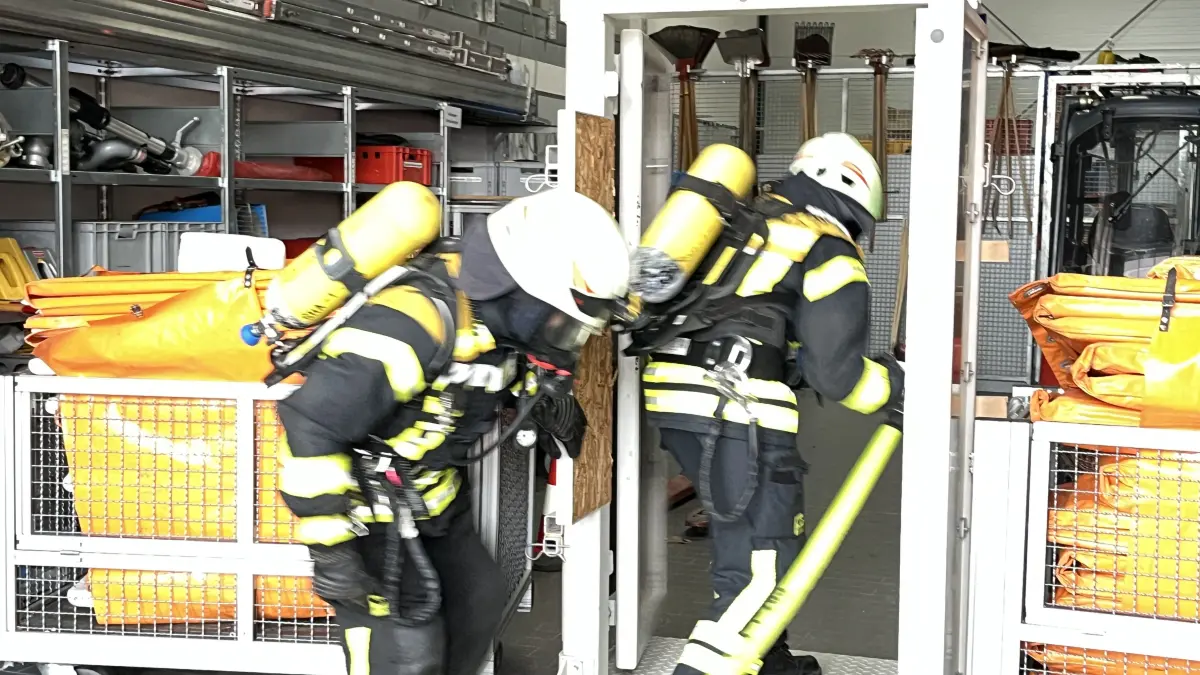 An einer der Stationen wird die Personenrettung geübt. Hintereinander und in leicht gebückter Haltung betreten zwei Feuerwehrleute durch eine Tür ein angeblich brennendes Haus. Gewissermaßen als „Ariadnefaden“ führen sie einen Schlauch mit sich, um sicher wieder herauszufinden.