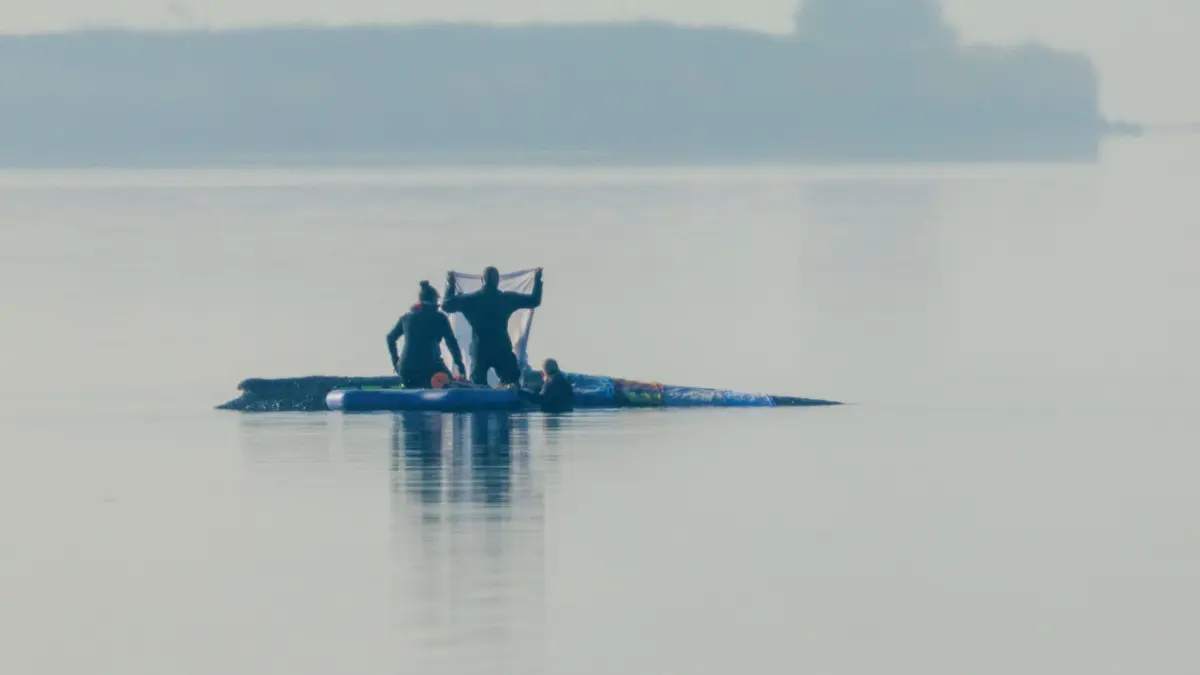 Rettungsaktion für den Buckelwal: 17.04.2026, Mecklenburg-Vorpommern, Kirchdorf (poel): Retter sind am Morgen in der Nähe des Buckelwal vor der Insel Poel und legen Tücher auf dem Walrücken aus. Für den bei Wismar gestrandeten Buckelwal soll der neue Rettungsversuch heute beginnen. Umgesetzt werden soll das Konzept von einer privaten Initiative. Foto: Jens Büttner/dpa +++ dpa-Bildfunk +++