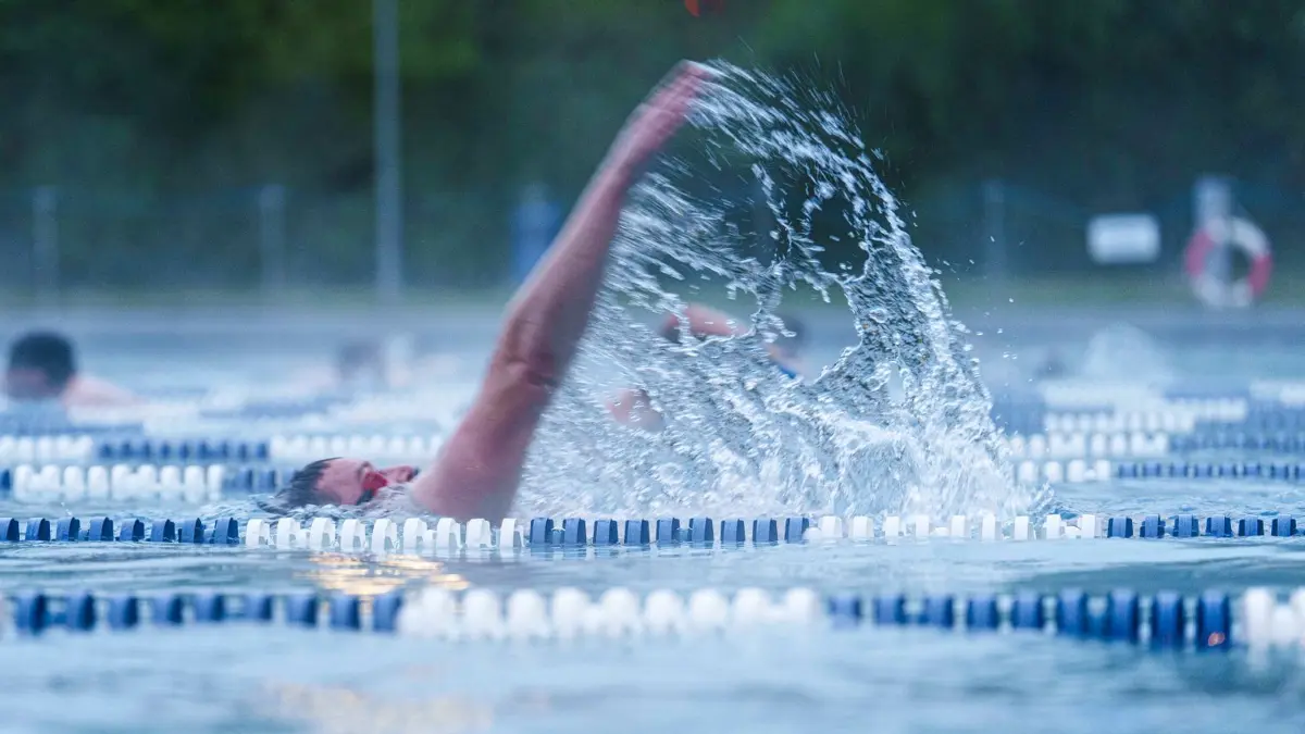 Erstes Frankfurter Freibad eröffnet Sommersaison: ARCHIV - 18.04.2025, Hessen, Frankfurt/Main: Frühschwimmer ziehen kurz nach Sonnenaufgang ihre Bahnen im Freibad Hausen. Das Freibad Hausen öffnet als erstes Frankfurter Freibad die Sommersaison am Karfreitag eröffnet. (zu dpa: «Die Freibadsaison startet – erste Freibäder öffnen») Foto: Andreas Arnold/dpa +++ dpa-Bildfunk +++