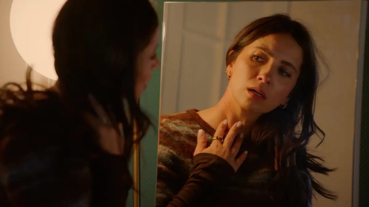 Laura (Chryssanthi Kavazi) betrachtet im Spiegel die Spuren ihres Kampfes mit Zoe.