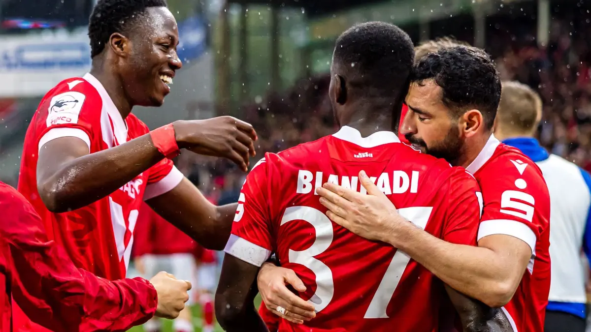 FC Energie Cottbus - Rot-Weiss Essen: 18.04.2026, Brandenburg, Cottbus: Fußball, Männer: 3. Liga, Energie Cottbus - Rot-Weiss Essen, 34. Spieltag, LEAG Energie Stadion. King Manu (FC Energie Cottbus, l) und Tolcay Cigerci (FC Energie Cottbus, r) beglückwünschen den Torschützen zum 5:3 Merveille Biankadi (FC Energie Cottbus) Foto: Frank Hammerschmidt/dpa +++ dpa-Bildfunk +++