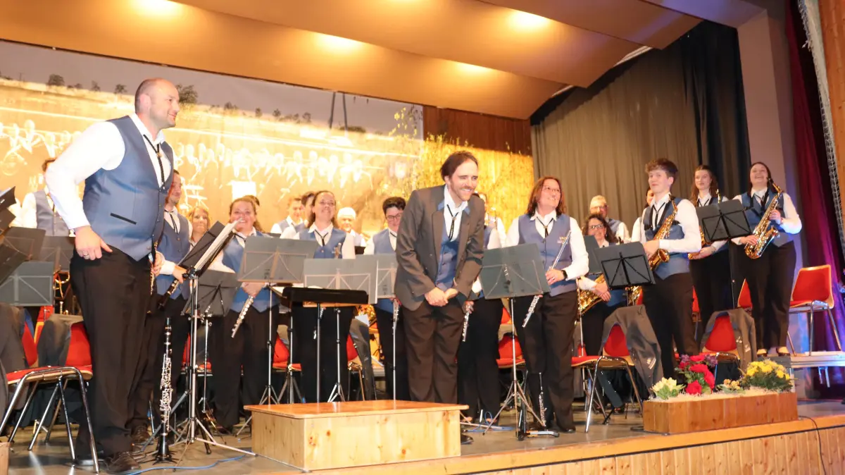 Vorsitzender Steffen Strobel und Dirigent René Klaiber mit den Bergfelder Musikerinnen und Musikern auf der Bühne.