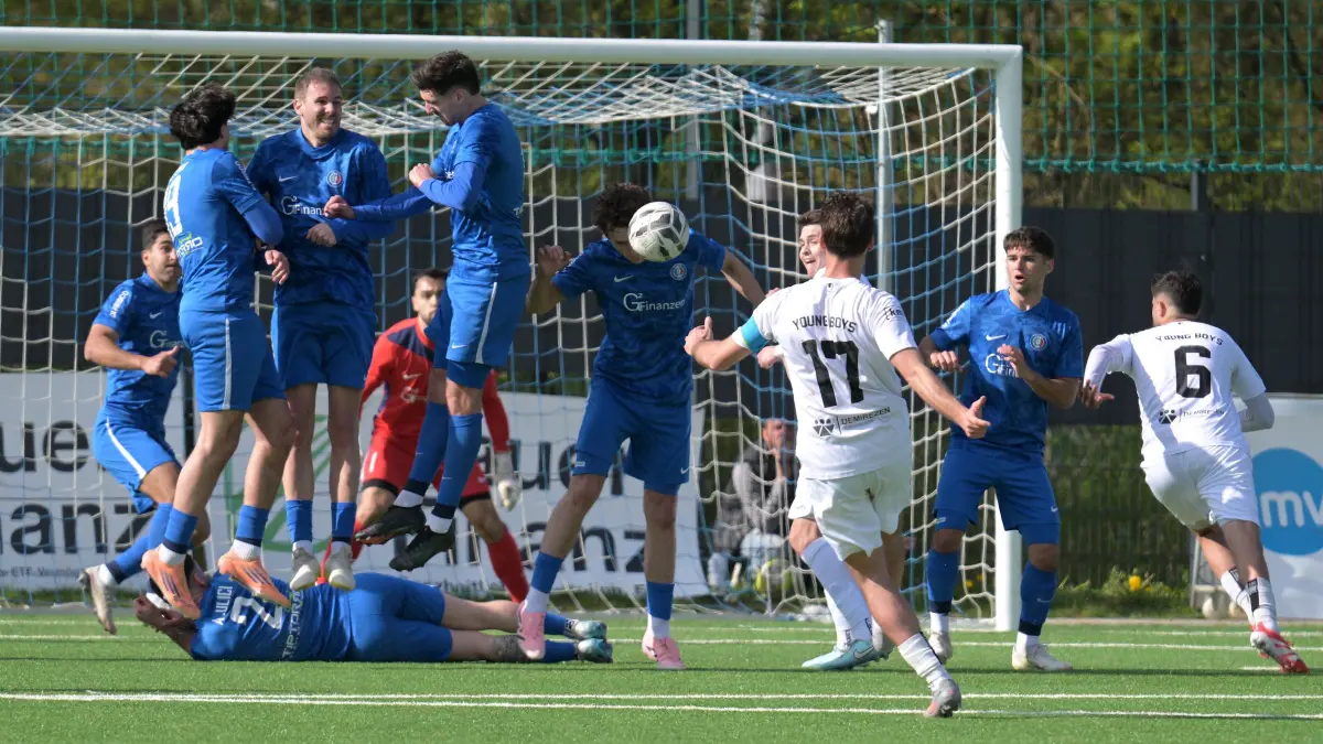Fussball VL | Young Boys Reutlingen vs. Calcio Leinfelden-Echterdingen: Fussball VL | Young Boys Reutlingen (weiss) vs. Calcio Leinfelden-Echterdingen (blau) // 2026-04-19 // Foto: Joachim Baur // kam auch beim Freistoss nicht durch die Abwehr von Calcio - #17 Hakan Aktepe (Young Boys Reutlingen) - #5 Nick Olteanu (Calcio LE) wehr mit dem Kopf ab