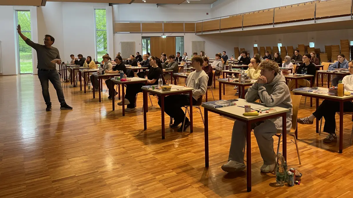 Schulleiter, Herr Nagel gibt den Abiturientinnen und Abiturienten eine kurze Einführung zu den Regeln während der Prüfung.