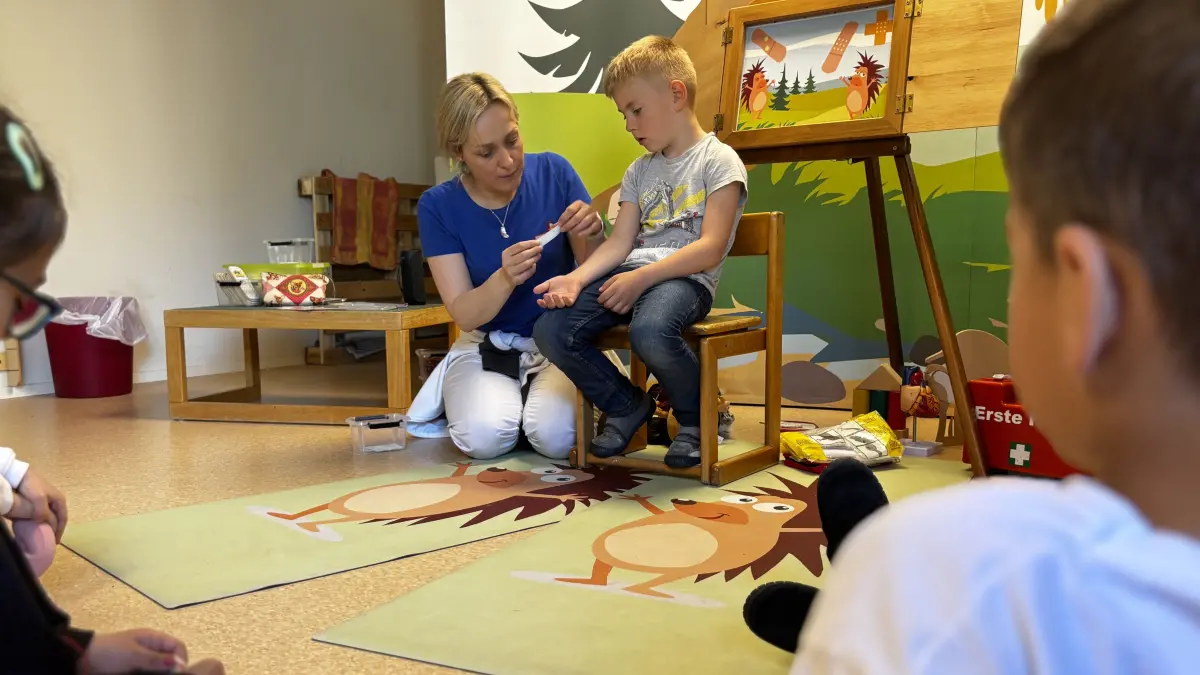 Christina Seiffert zeigt den Dettinger Kita-Kindern, welche Utensilien sich in einem Verbandskasten finden.